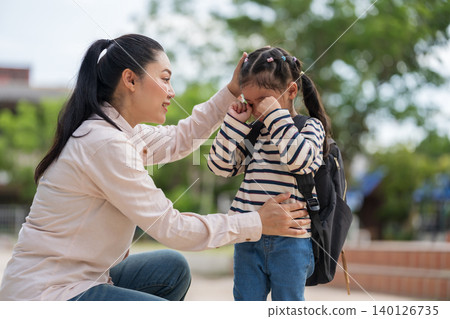 Loving mother comforting her crying daughter who doesn't want to go to school. First day of school anxiety concept. 140126735