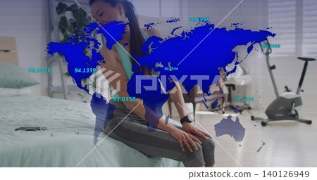 Sitting woman wearing teal-tank and smartwatch holding lower-back on bed at home, with blue AR map Sitting woman wearing teal-tank and smartwatch holding lower-back on bed at home, with blue AR map 140126949
