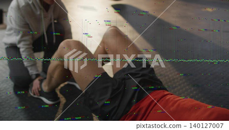 Performing man doing situps on gym mat in red tee, partner bracing feet, battle rope, glitch Performing man doing situps on gym mat in red tee, partner bracing feet, battle rope, glitch 140127007