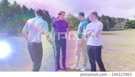 Standing four men chatting on fairway wearing polos and trousers, with golf club and sun flare Standing four men chatting on fairway wearing polos and trousers, with golf club and sun flare 140127063
