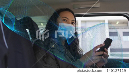 Holding phone, woman in surgical mask, dark jacket in rear-seat looking at window with wave overlay Holding phone, woman in surgical mask, dark jacket in rear-seat looking at window with wave overlay 140127119