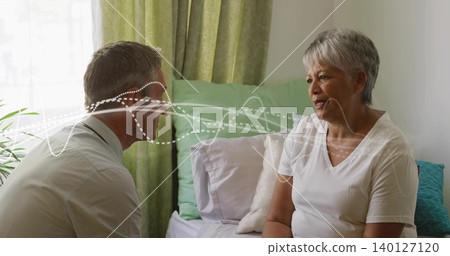 Talking man wearing suspenders leaning toward older woman on bed, with waveform overlay Talking man wearing suspenders leaning toward older woman on bed, with waveform overlay 140127120