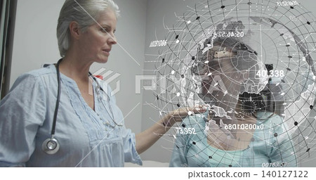 Standing clinician touching seated patient with glasses in clinic, stethoscope and AR globe overlay Standing clinician touching seated patient with glasses in clinic, stethoscope and AR globe overlay 140127122