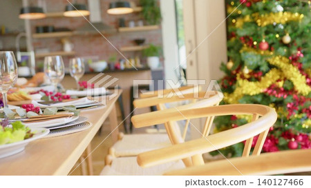 Three light-wood chairs are lining flat design dining room with Christmas tree home decor Three light-wood chairs are lining flat design dining room with Christmas tree home decor 140127466