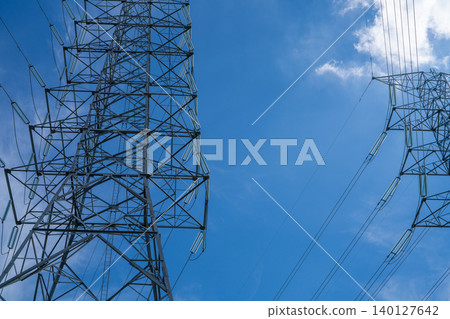 Electricity pylon and power transmission lines against blue sky. Energy supply, technological engineering, and efficiency of modern grid systems. High voltage tower provide electric power transmission 140127642