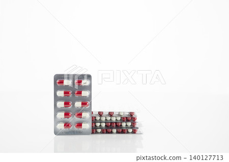 Red and white antibiotic capsule pill in blister pack. Prescription drug clindamycin 300 mg for bacterial infection treatment healthcare and pharmaceutical use. Healthcare and medicine industry. 140127713