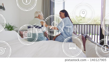 Supporting senior man on bed, caregiver in blue scrubs talking by sliding glass door, HUD icons Supporting senior man on bed, caregiver in blue scrubs talking by sliding glass door, HUD icons 140127905