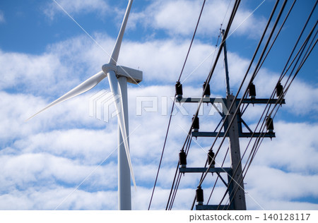 High-voltage electric pylon channels renewable wind energy into grid. Innovation in clean power infrastructure and sustainable environmental transformation. Wind turbines supply green electricity. High-voltage electric pylon channels renewable wind energy into grid. Innovation in clean power infrastructure and sustainable environmental transformation. Wind turbines supply green electricity. 140128117