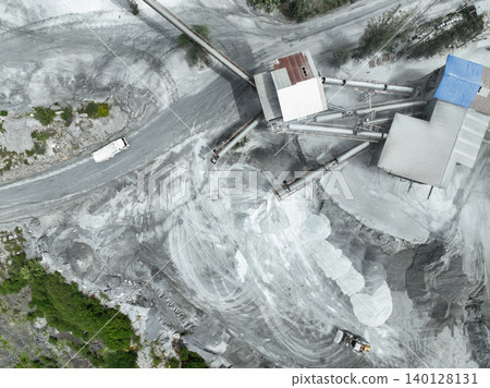 Aerial view of granite and limestone crushing plant with dump trucks and excavators processing raw stone into construction aggregates for concrete and infrastructure development. Stone mill factory. 140128131