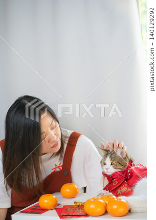 chinese new year concept with asian woman play with cat wearing red chinese traditional cloth with red envelope orange and gold on table chinese new year concept with asian woman play with cat wearing red chinese traditional cloth with red envelope orange and gold on table 140129292