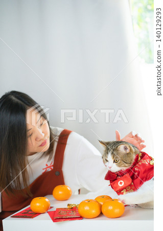 chinese new year concept with asian woman play with cat wearing red chinese traditional cloth with red envelope orange and gold on table chinese new year concept with asian woman play with cat wearing red chinese traditional cloth with red envelope orange and gold on table 140129293
