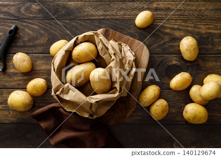 Fresh raw whole potatoes on rustic wooden table, top view Fresh raw whole potatoes on rustic wooden table, top view 140129674