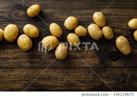 Fresh raw whole potatoes on rustic wooden table, top view Fresh raw whole potatoes on rustic wooden table, top view 140129675