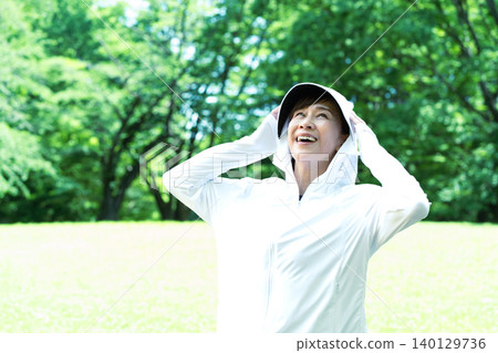 Senior women exercising while using UV protection. 140129736