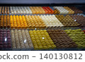 A vibrant display of macarons in various colors, arranged neatly in trays, highlighting their smooth textures and appealing designs, perfect for French dessert lovers 140130812