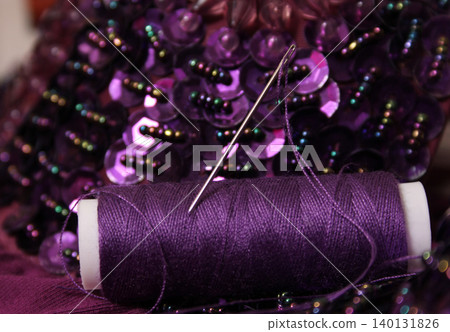 Spool of Purple Thread on Beaded Fabric Spool of Purple Thread on Beaded Fabric 140131826