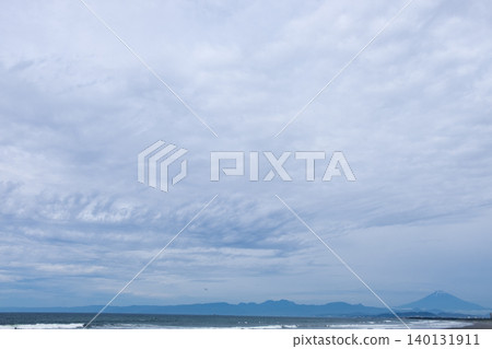 A silhouette of Mount Fuji and a vast, cloudy sky viewed from Shonan Beach. A silhouette of Mount Fuji and a vast, cloudy sky viewed from Shonan Beach. 140131911