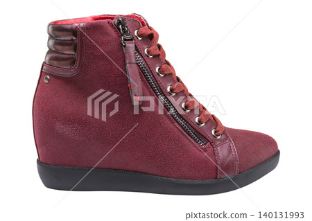 Women burgundy suede wedge sneakers isolated on white background. Casual maroon high-top ankle boots with hidden heel and side zipper, side view. Women burgundy suede wedge sneakers isolated on white background. Casual maroon high-top ankle boots with hidden heel and side zipper, side view. 140131993