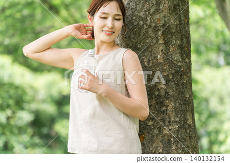 一位婦女在森林裡喝水（補充水分，礦泉水，鈉） 140132154