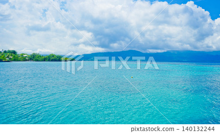 beautiful view of tropical beach with mountain backdrop and clear sky 140132244