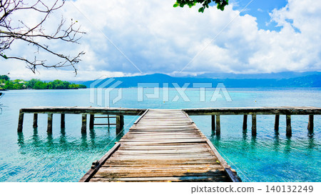 beautiful view of tropical beach with mountain backdrop and clear sky 140132249