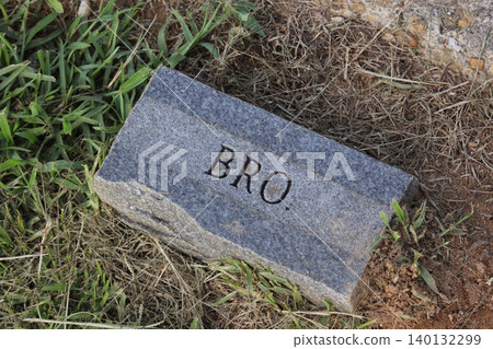 Old Brick Stone in Cemetery With Word Bro Engraved Old Brick Stone in Cemetery With Word Bro Engraved 140132299