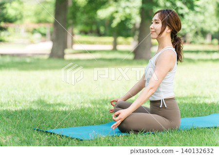 一位女性瑜珈教練在公園和森林裡教授瑜珈、瑜珈課程和皮拉提斯。 一位女性瑜珈教練在公園和森林裡教授瑜珈、瑜珈課程和皮拉提斯。 140132632