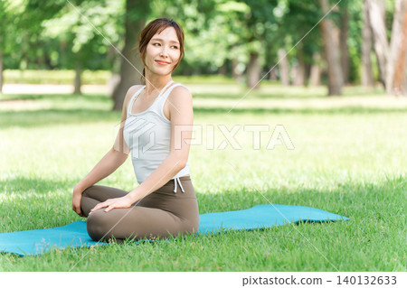 一位女性瑜珈教練在公園和森林裡教授瑜珈、瑜珈課程和皮拉提斯。 一位女性瑜珈教練在公園和森林裡教授瑜珈、瑜珈課程和皮拉提斯。 140132633