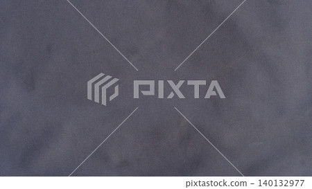 Full-frame close up of a soft dark grey microfiber cloth or suede fabric texture. Featuring subtle organic folds smooth pile directions and rich shadow depths. Full-frame close up of a soft dark grey microfiber cloth or suede fabric texture. Featuring subtle organic folds smooth pile directions and rich shadow depths. 140132977
