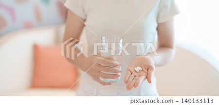 woman hand holding medicine painkiller pill and water glass on the sofa at home, taking for headaches, stomach ache, Diarrhea Pain from food poisoning, Endometriosis, Hysterectomy and Menstrual woman hand holding medicine painkiller pill and water glass on the sofa at home, taking for headaches, stomach ache, Diarrhea Pain from food poisoning, Endometriosis, Hysterectomy and Menstrual 140133113