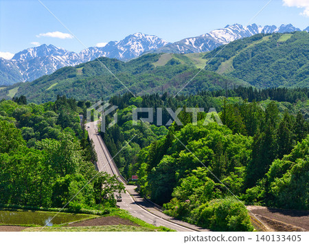 Tsugaike Panorama Park, enveloped in fresh greenery, and the snow-capped Hakuba mountain range in Otari Village, Nagano Prefecture (aerial photograph taken by drone). 140133405