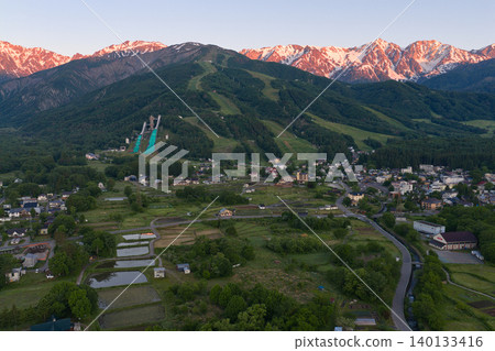 The beautiful morning glow over the Hakuba mountain range and the lush greenery of Hakuba Village, Nagano Prefecture (aerial photography by drone) The beautiful morning glow over the Hakuba mountain range and the lush greenery of Hakuba Village, Nagano Prefecture (aerial photography by drone) 140133416