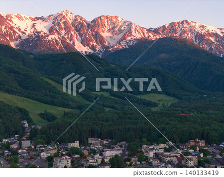 The beautiful morning glow over the Hakuba Three Peaks and the lush greenery of Hakuba Village, Nagano Prefecture (aerial photography by drone) The beautiful morning glow over the Hakuba Three Peaks and the lush greenery of Hakuba Village, Nagano Prefecture (aerial photography by drone) 140133419