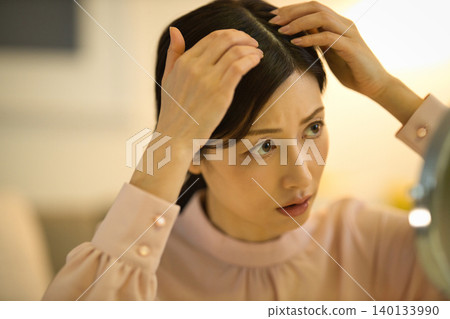 Middle-aged women who are concerned about their hairline during their nighttime skincare routine Middle-aged women who are concerned about their hairline during their nighttime skincare routine 140133990