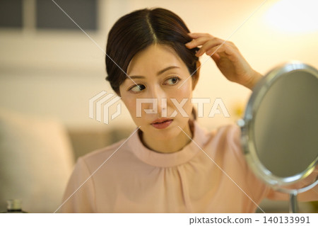 Middle-aged women who are concerned about their hairline during their nighttime skincare routine Middle-aged women who are concerned about their hairline during their nighttime skincare routine 140133991