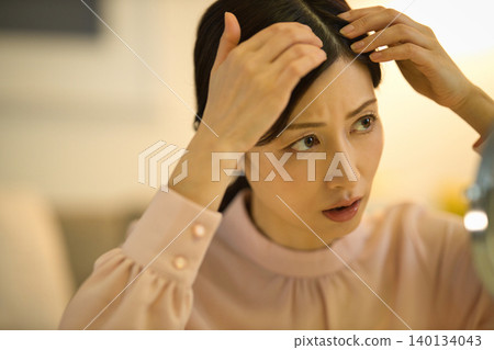 中年女性在夜間護膚過程中會擔心髮際線問題。 中年女性在夜間護膚過程中會擔心髮際線問題。 140134043