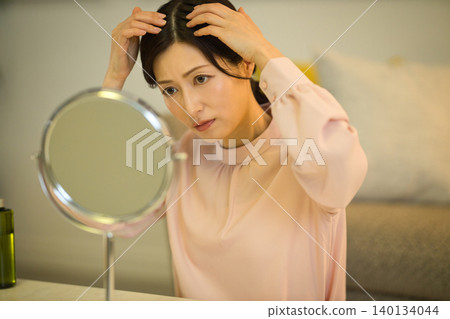 中年女性在夜間護膚過程中會擔心髮際線問題。 中年女性在夜間護膚過程中會擔心髮際線問題。 140134044