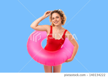 Woman poses with pink float, bright backdrop. Summer vibes and joyful concept 140134222