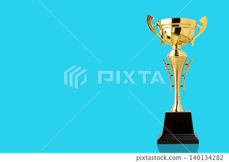 Golden trophy shines on a blue surface, symbolizing success Golden trophy shines on a blue surface, symbolizing success 140134282