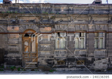 Ruined building with arched doorway and cracked stone walls Ruined building with arched doorway and cracked stone walls 140136395