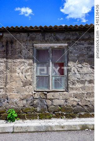 Weathered stone house with single window Weathered stone house with single window 140136436