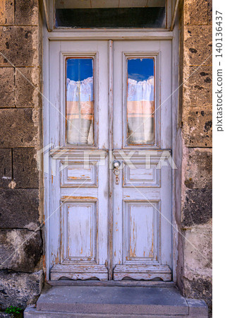 Weathered white door on stone building Weathered white door on stone building 140136437