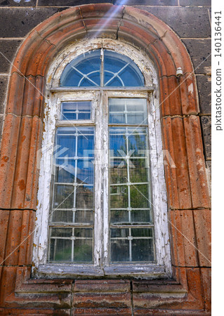 Weathered arched window in rustic brick building Weathered arched window in rustic brick building 140136441
