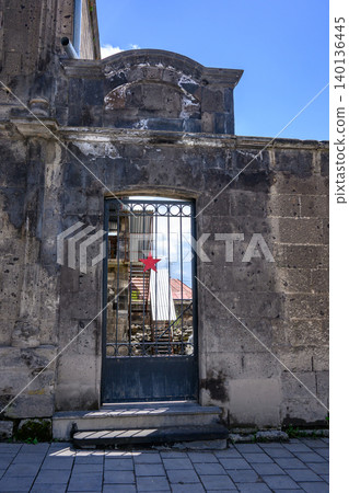 Old stone gate with metal bars and red star Old stone gate with metal bars and red star 140136445