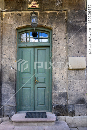 Rustic, green-painted wooden door set in stone wall Rustic, green-painted wooden door set in stone wall 140136472