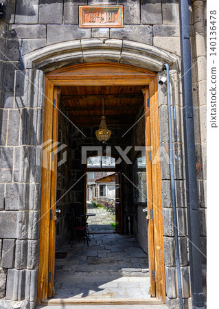 Historic stone entrance with wooden door, lantern, and view into courtyard Historic stone entrance with wooden door, lantern, and view into courtyard 140136478