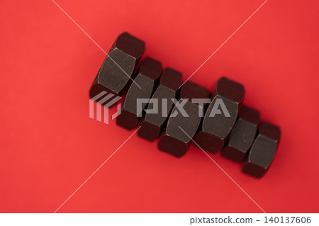 紅色背景中的六角螺栓螺母 紅色背景中的六角螺栓螺母 140137606