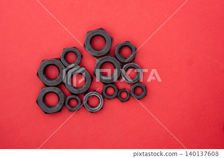 Hexagonal bolt and nut on a red background 140137608