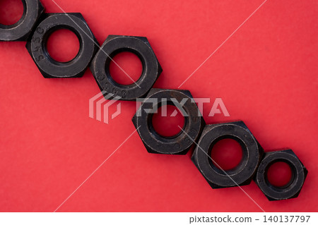 Hexagonal bolt and nut on a red background 140137797