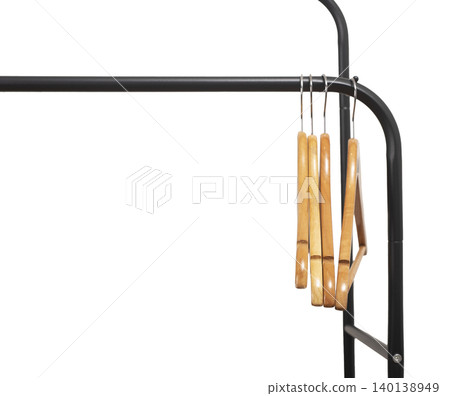 Wooden hangers stacked vertically on black metal rack corner. Garment holders aligned on horizontal bar. Interior storage scene for wardrobe, retail, organization concept.. Wooden hangers stacked vertically on black metal rack corner. Garment holders aligned on horizontal bar. Interior storage scene for wardrobe, retail, organization concept.. 140138949